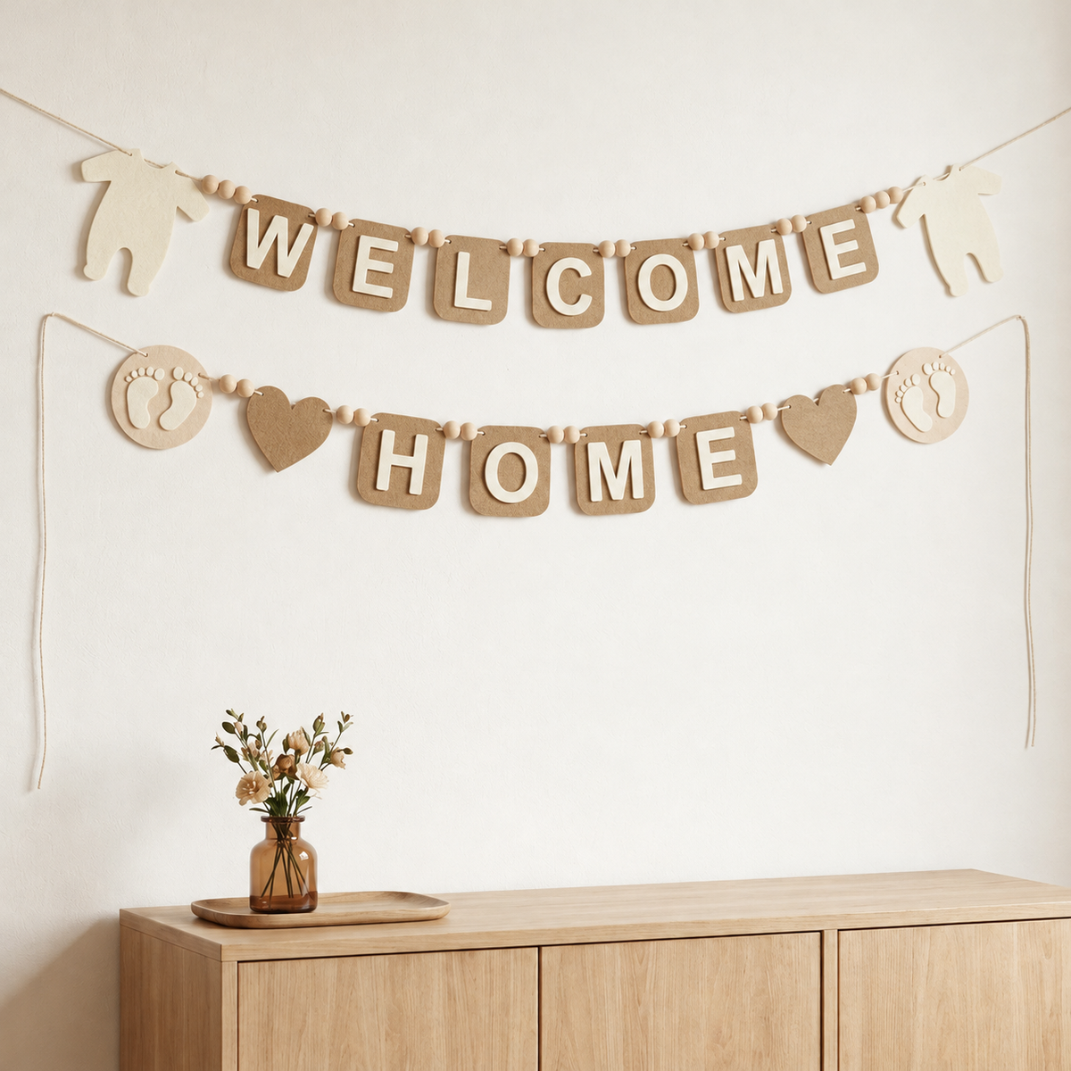 Tan WELCOME HOME felt garland with baby bodysuit shapes, footprints and hearts