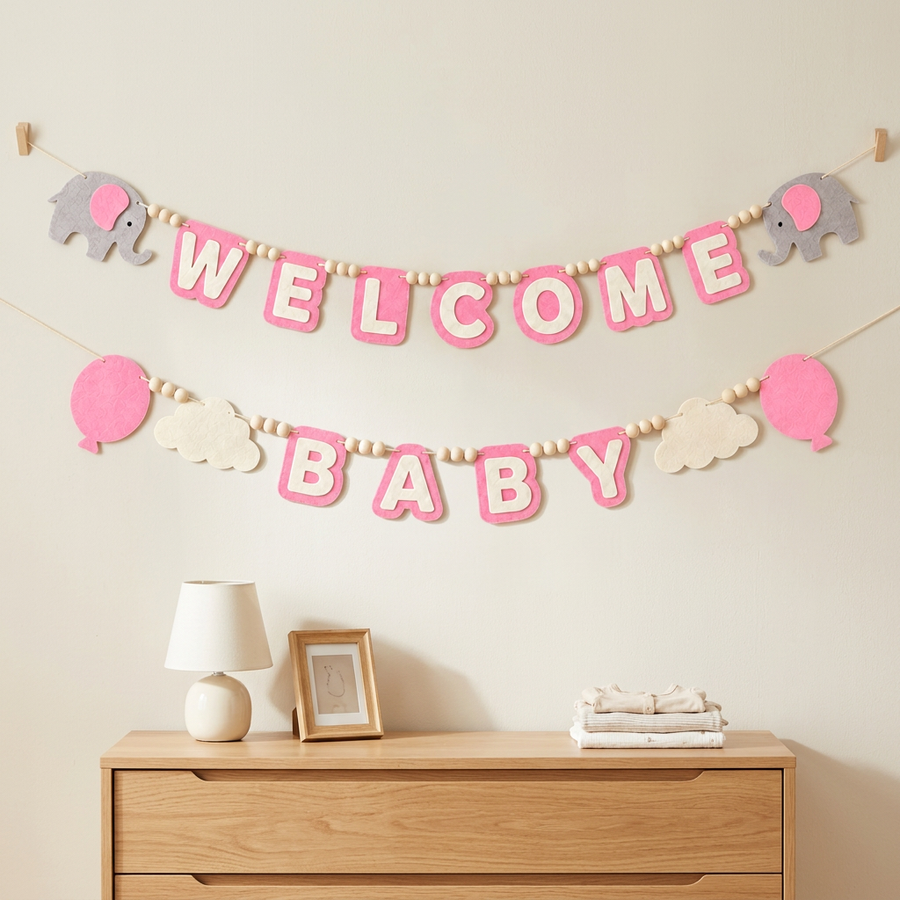 Pink WELCOME BABY felt garland displayed on a nursery wall
