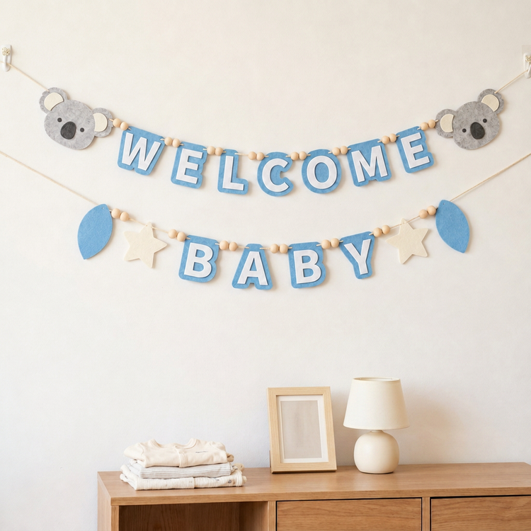 Blue WELCOME BABY felt garland displayed on a nursery wall