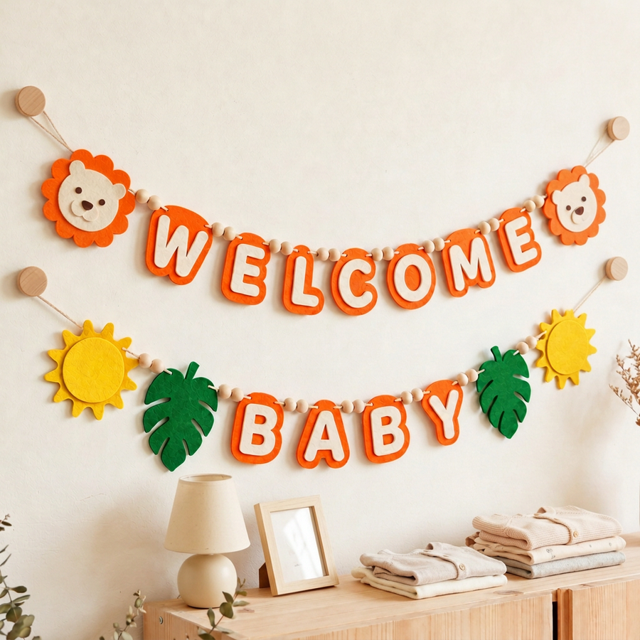 Orange WELCOME BABY felt garland displayed on a nursery wall