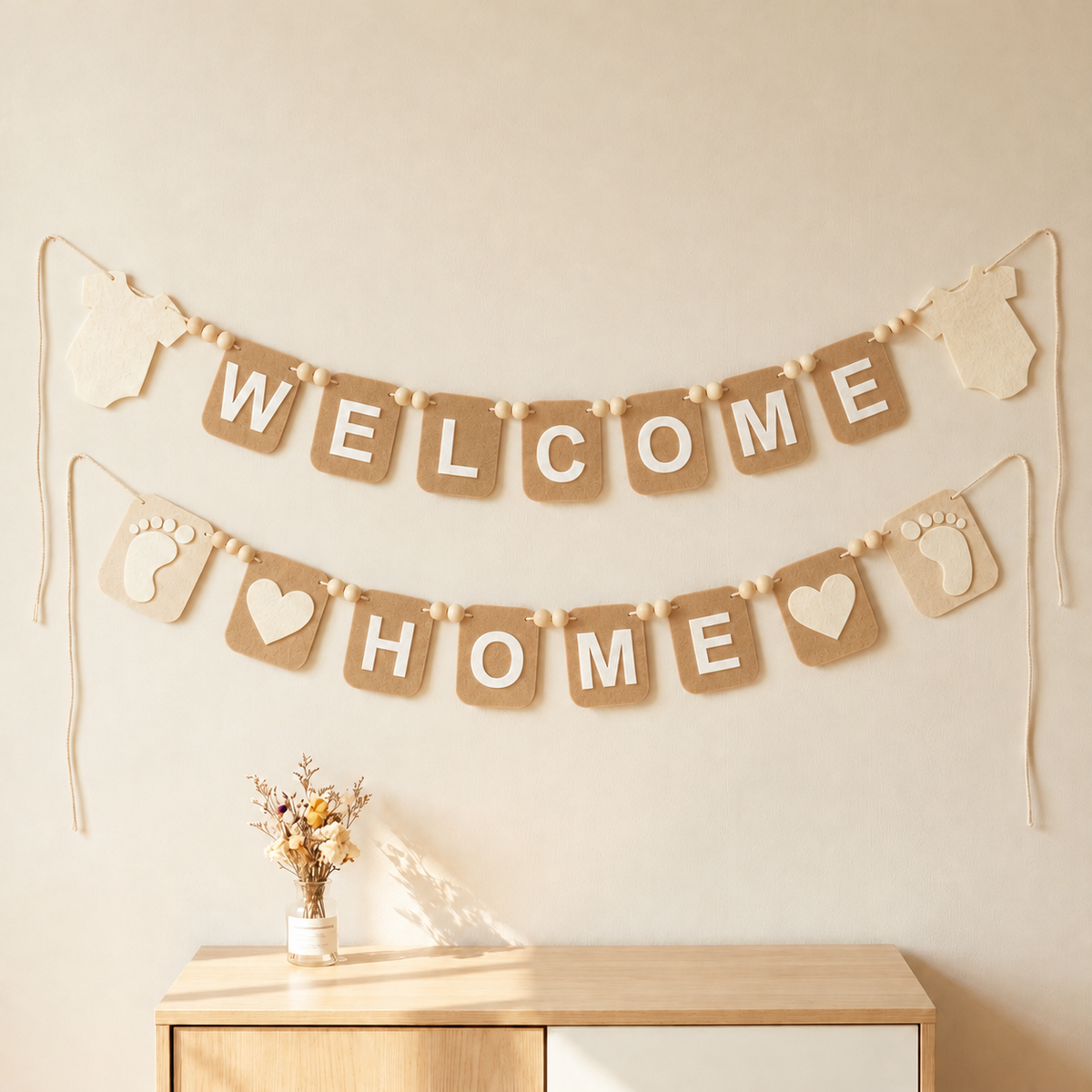 Tan WELCOME HOME felt garland with baby bodysuit shapes, footprints and hearts